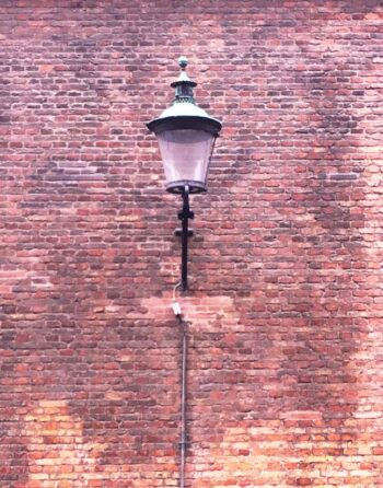 It's just a large street lamp on a wall of weathered brick, but the combination is oddly beautiful.