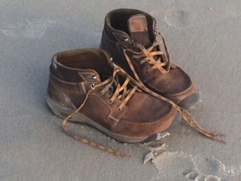 A pair of gold boots sit quietly on the Gold Coast, awaiting the return of their owner. Looks like someone went for a swim!